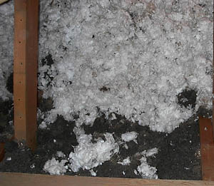 White loose fiberglass insulation blown in on top of the Black Rockwool insulation